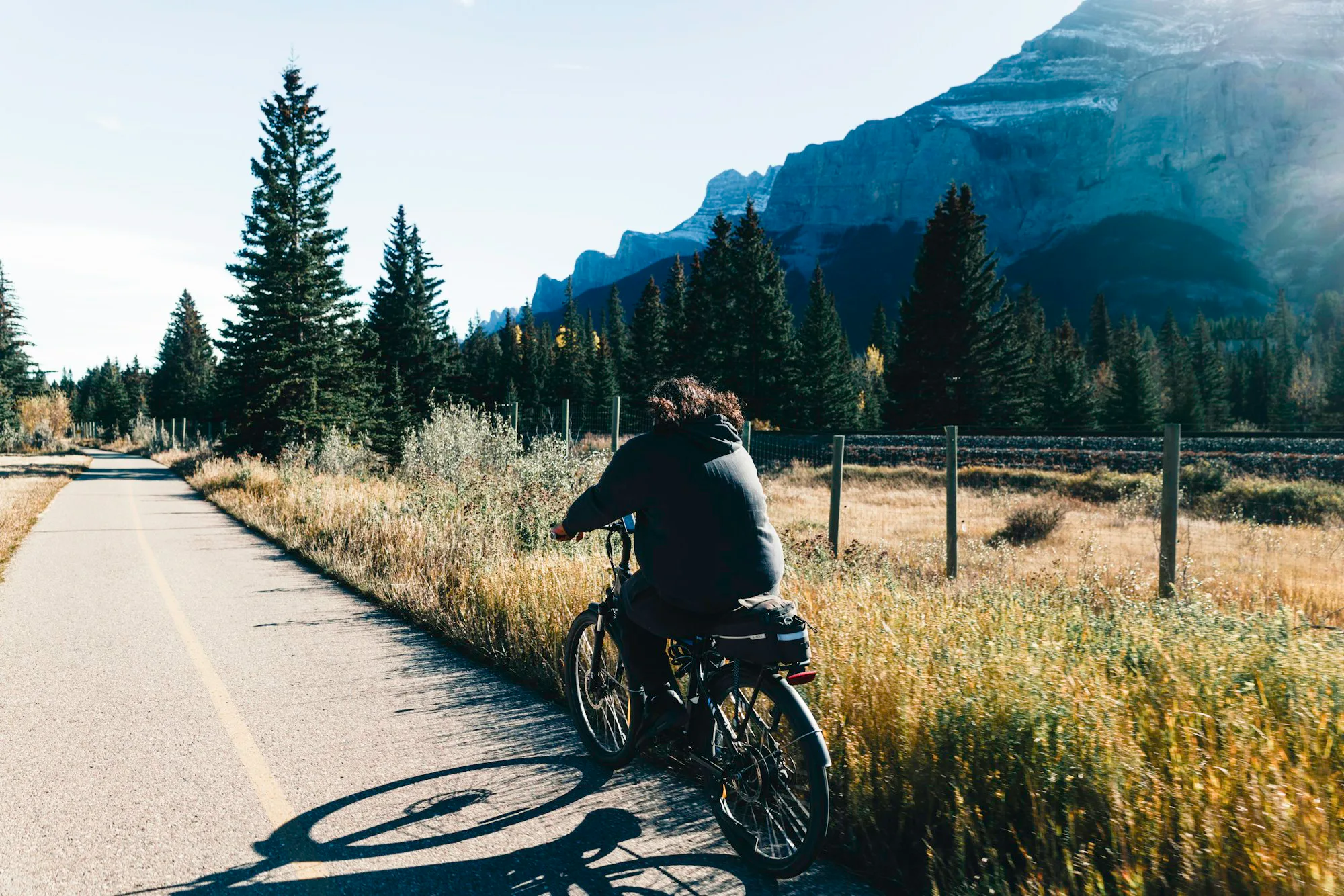 A cyclist on a quiet path towards mountains