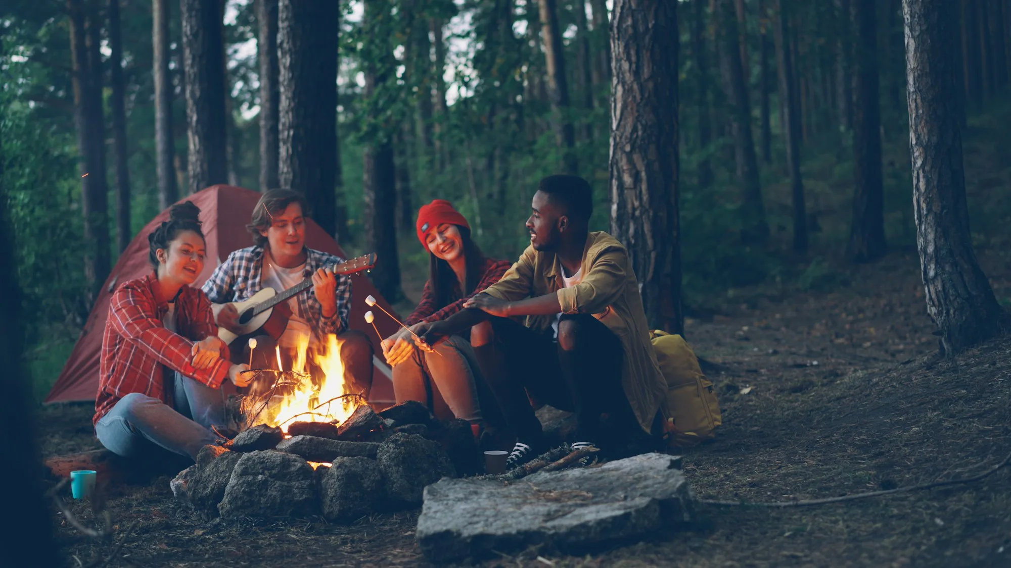 Friends gathered around a campfire in a forest