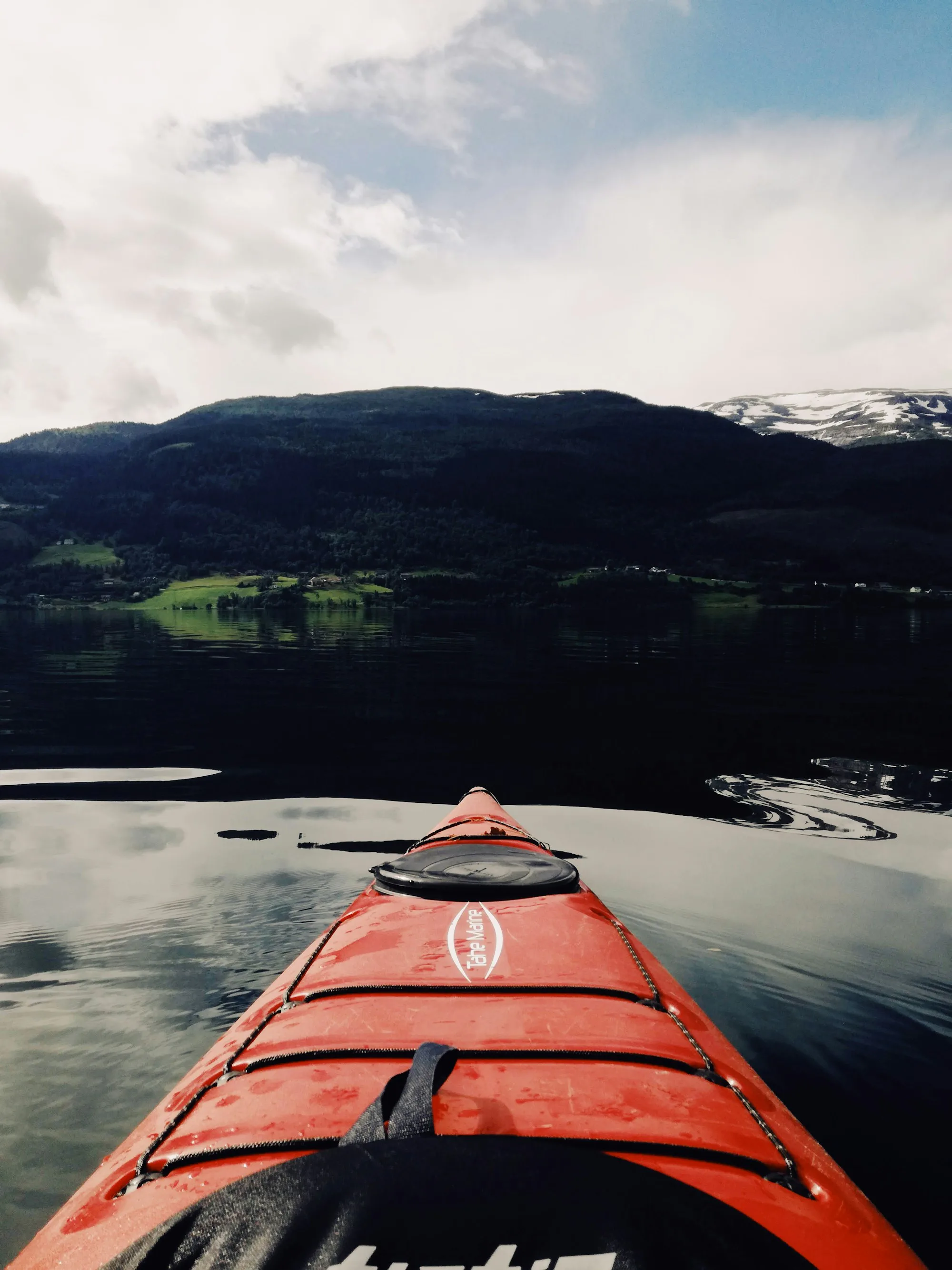 Looking over the bow of a red kayak across a lake