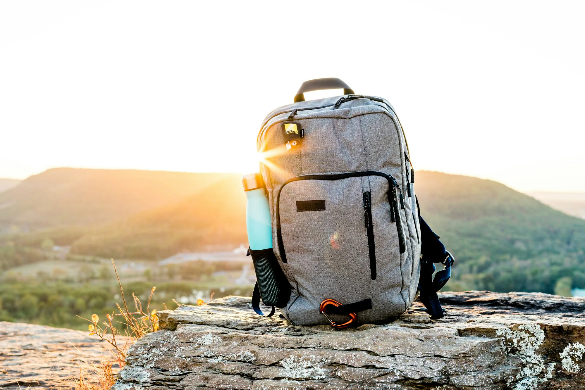 A grey hiking pack on a rock at sunset