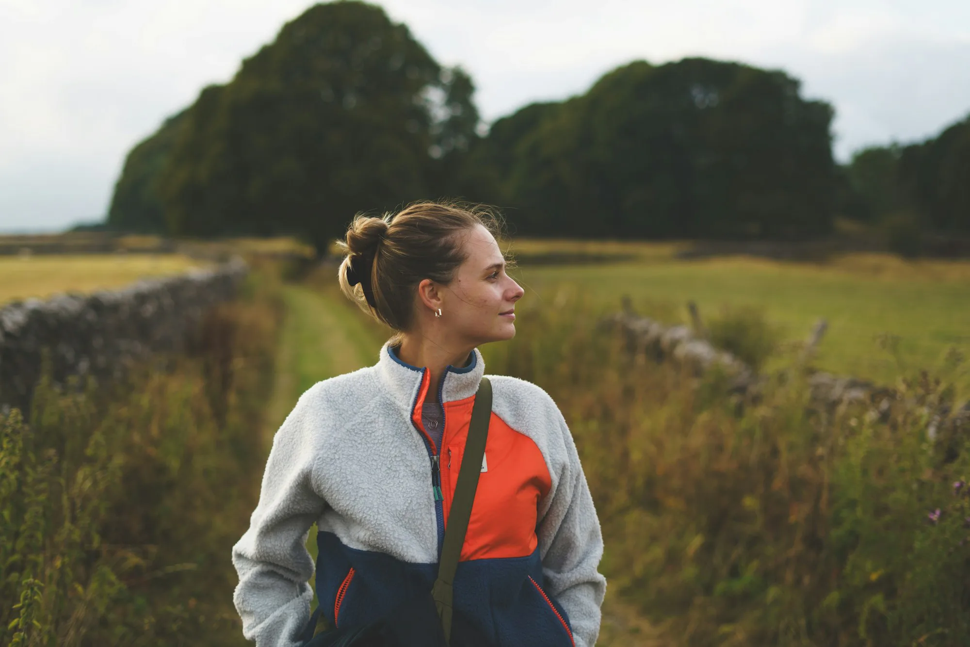 A woman in a fleece jacket standing in a meadow