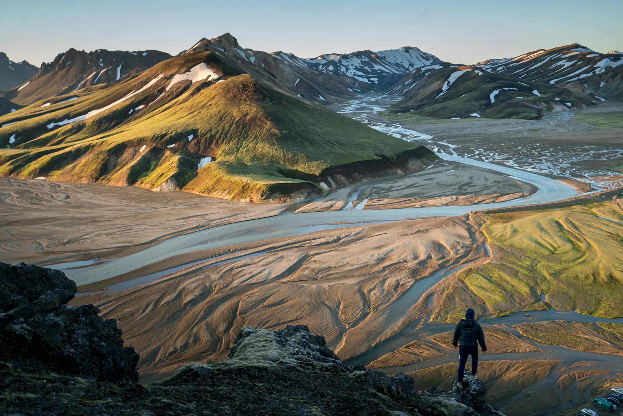A walker above a braided river valley in the Icelandic highlands