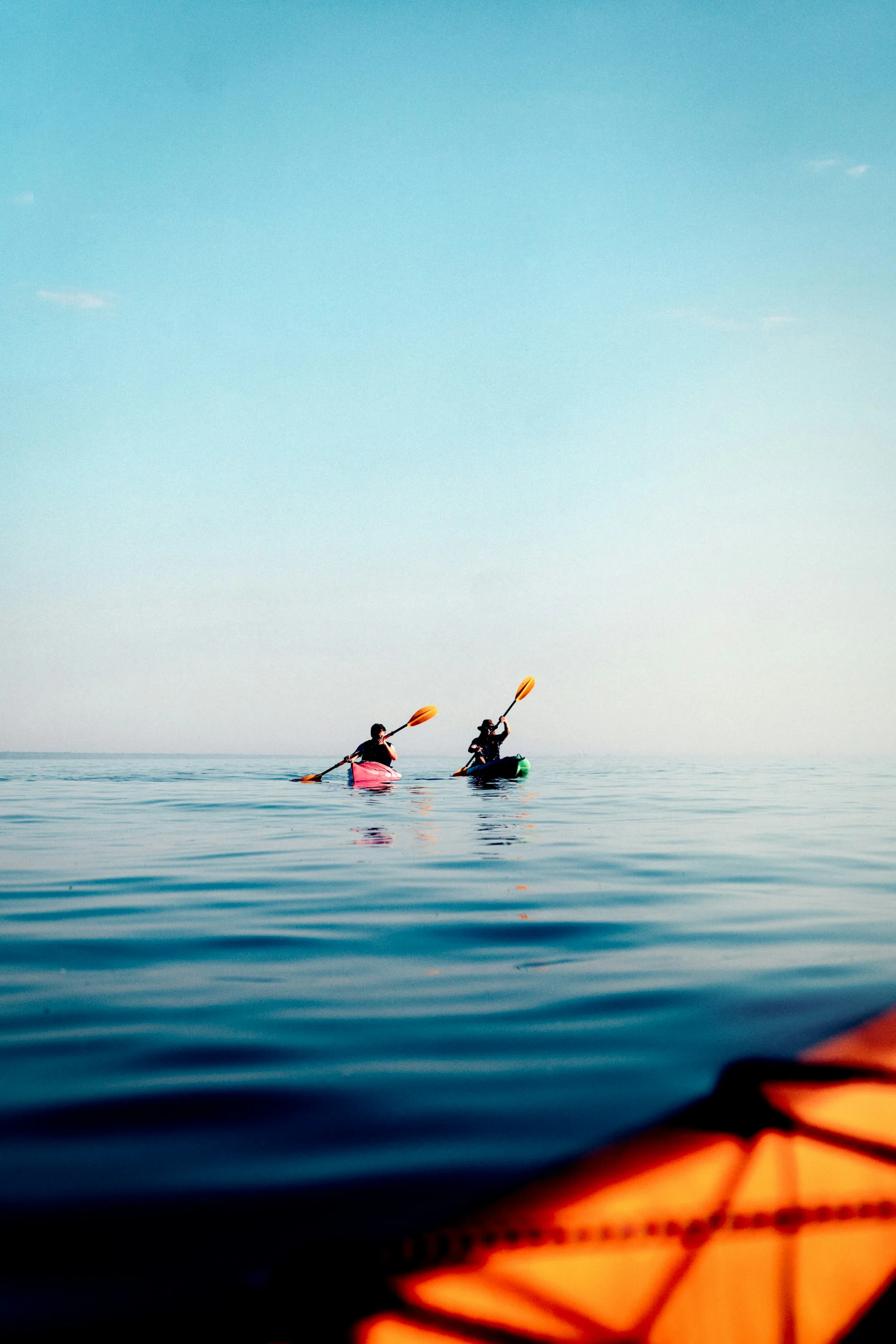 A kayaker on a calm, bright blue sea