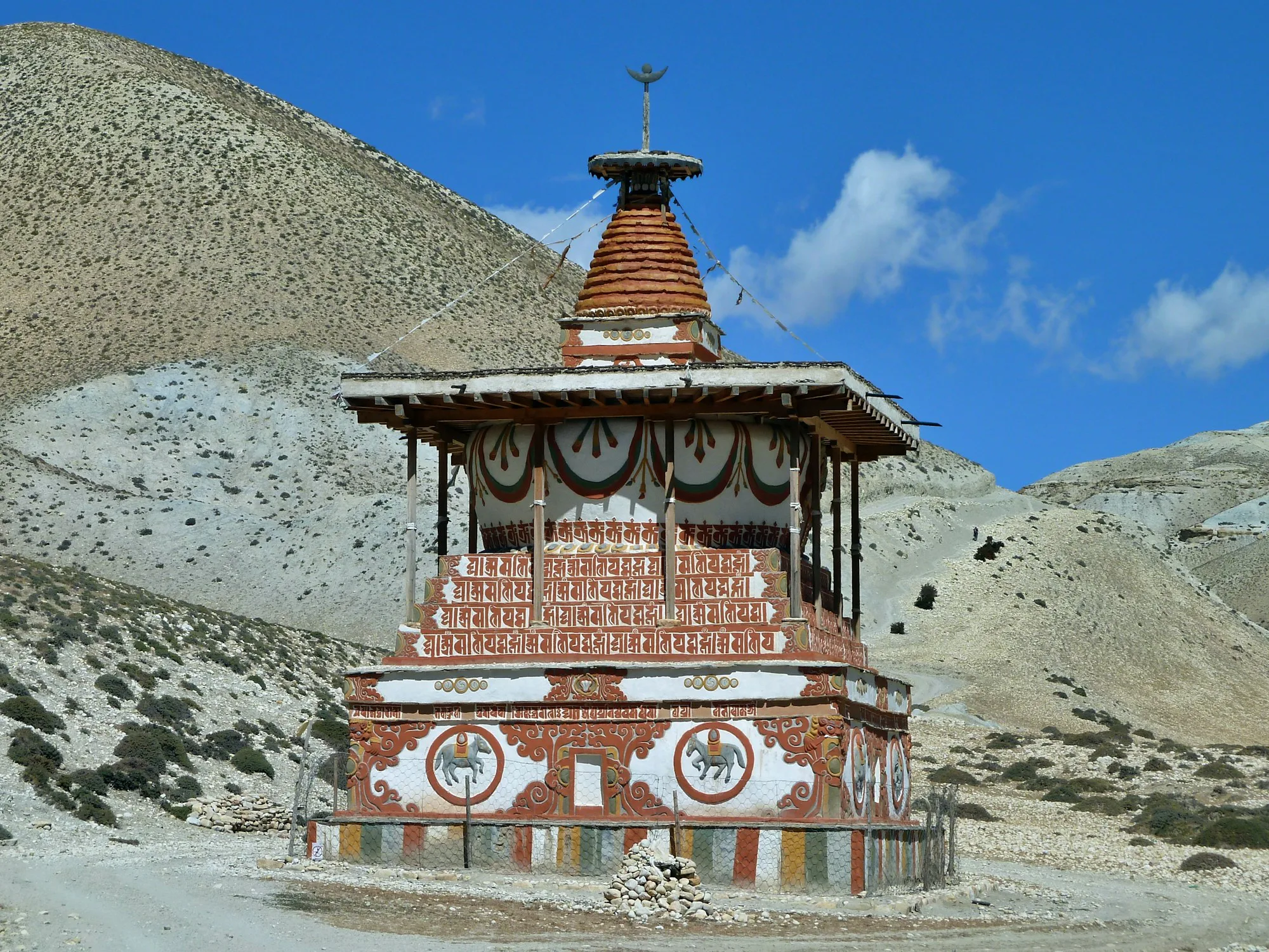 A painted Buddhist chorten in a dry mountain valley in Mustang