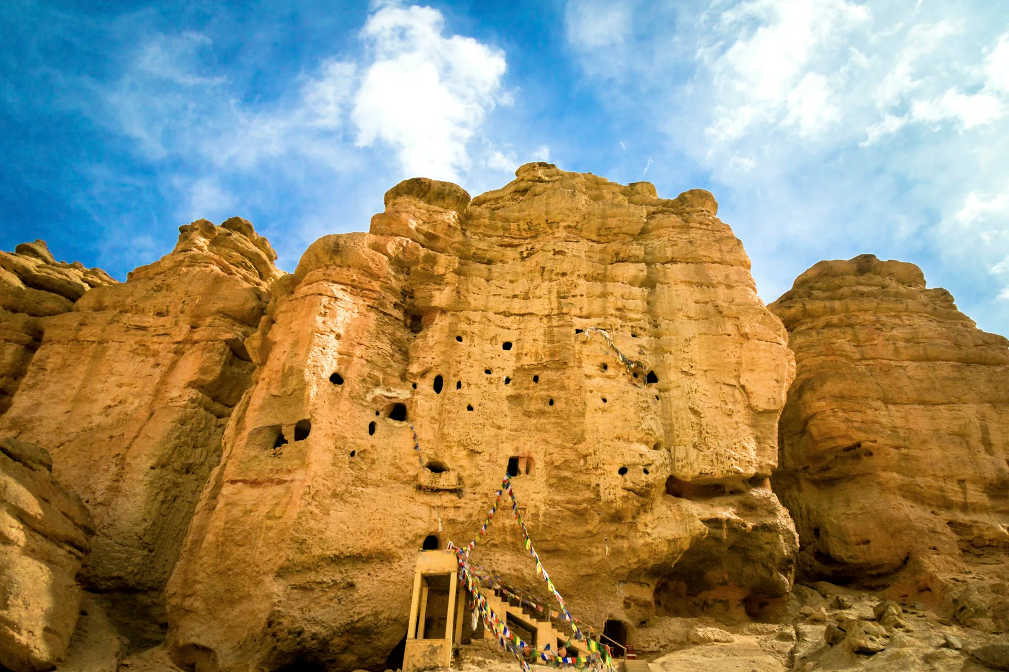 Ancient cave dwellings carved into sandstone cliffs in Upper Mustang