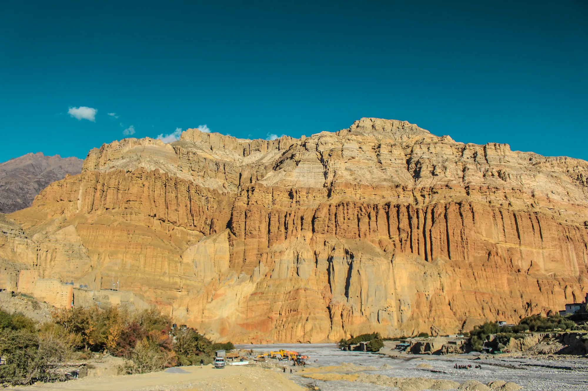 Red and ochre cliffs in the high desert of Upper Mustang under a blue sky