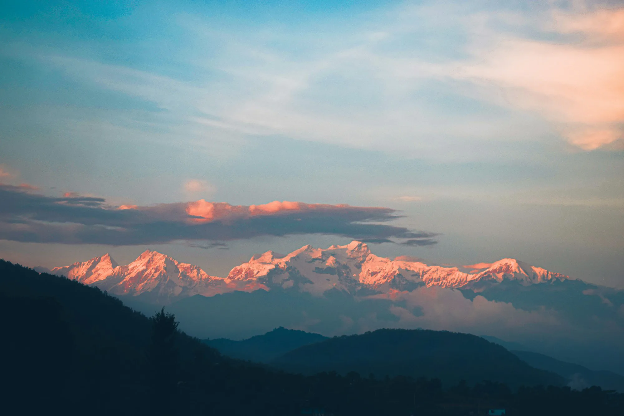 Sunrise turning the Annapurna range pink above dark hills
