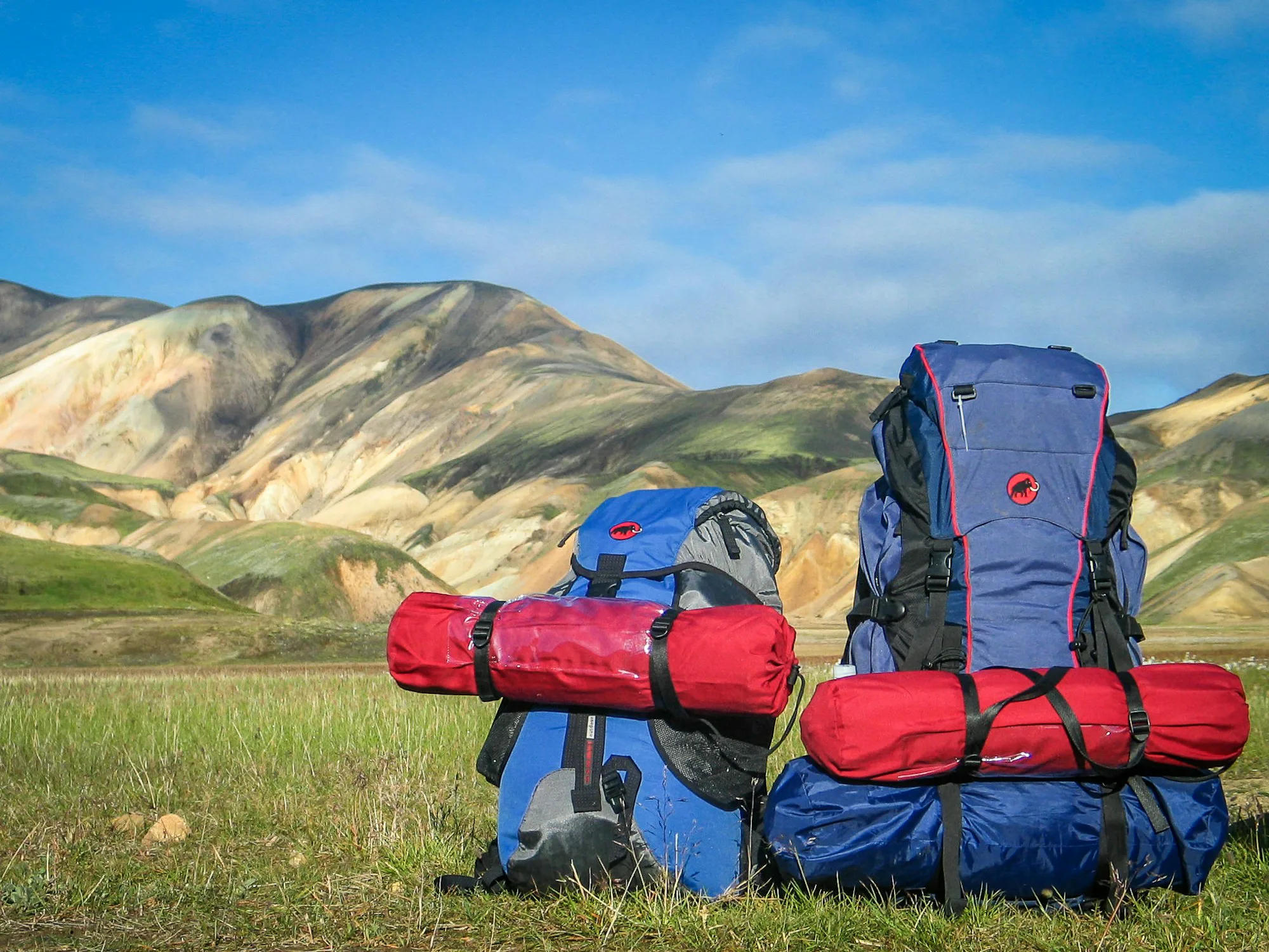 Hiking packs on the grass with mountains behind
