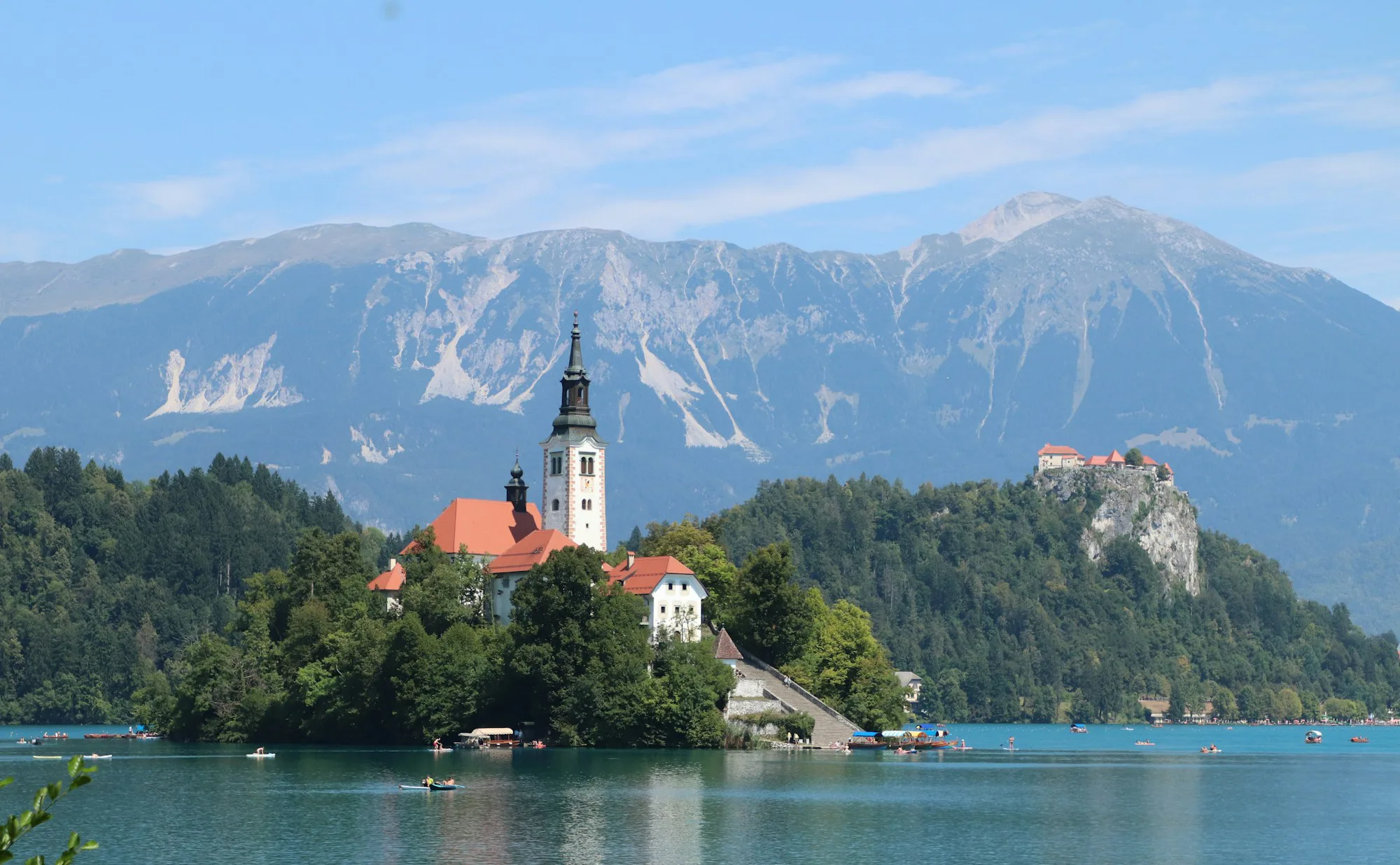 A church on a small island in a lake below the Julian Alps