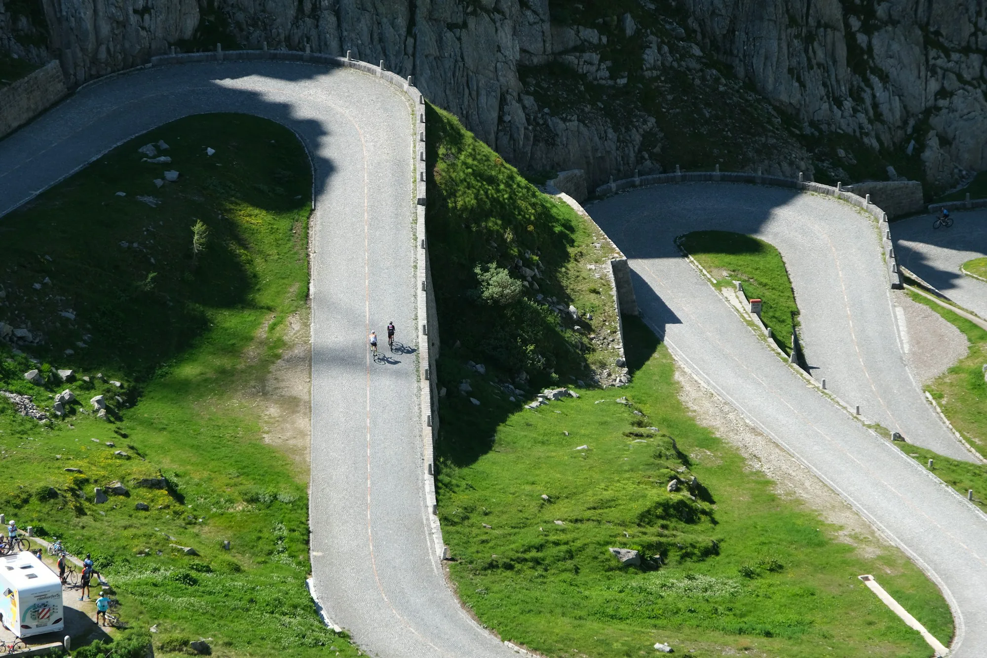 Hairpin bends of a mountain road on green slopes