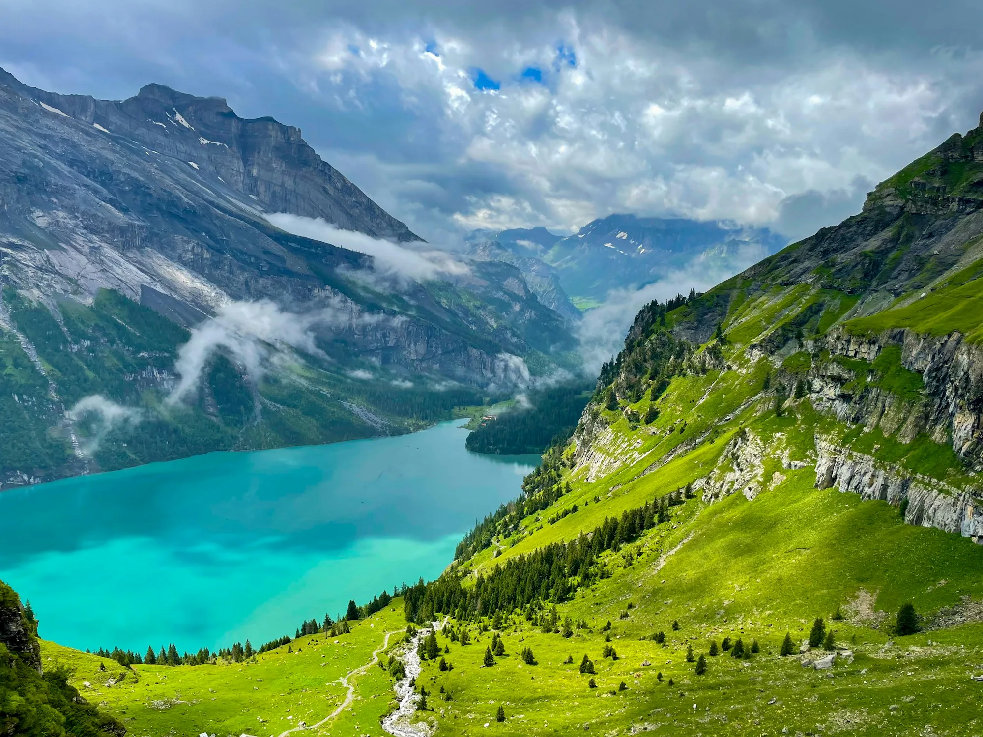 A turquoise alpine lake between bright green slopes