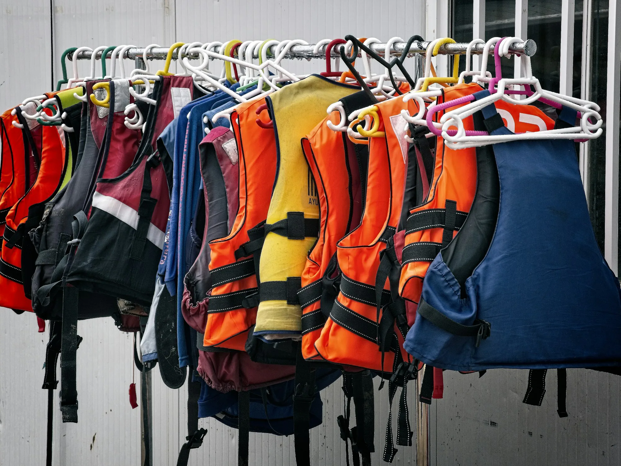 Brightly coloured buoyancy aids hanging on a rack
